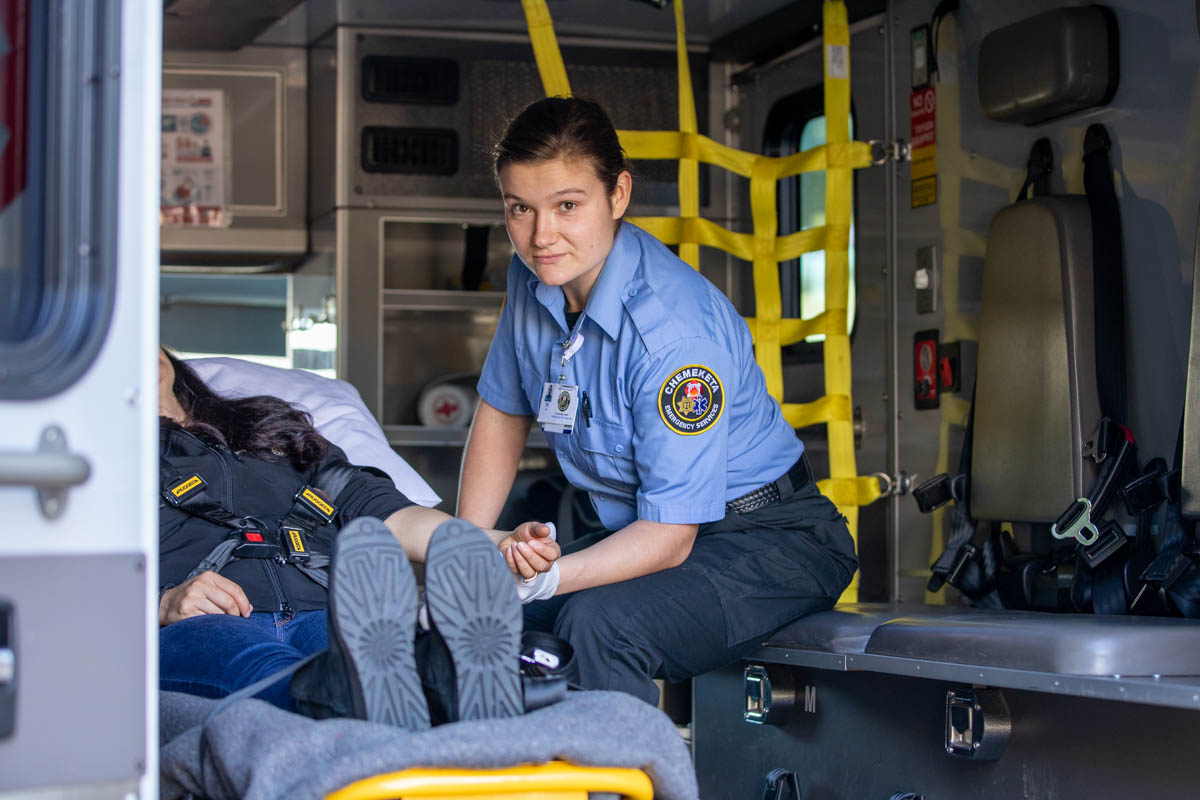 Woman EMT professional in ambulance with a patient